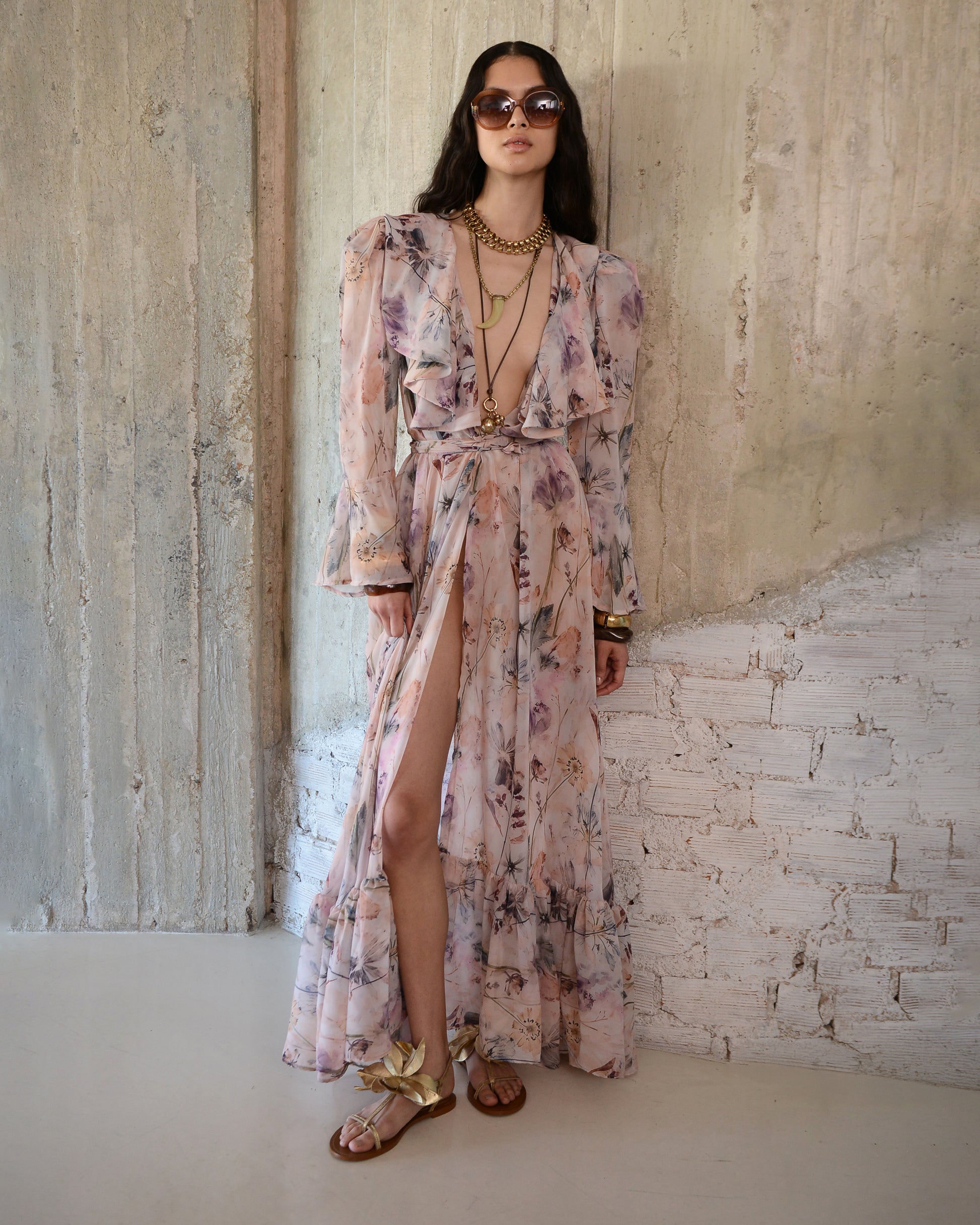 Woman wearing a floral dress with a textured wall background
